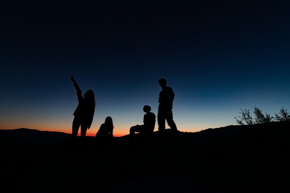 Menschen stehen zusammen und erwarten den Sonnenaufgang