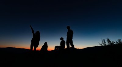 Menschen stehen zusammen und erwarten den Sonnenaufgang